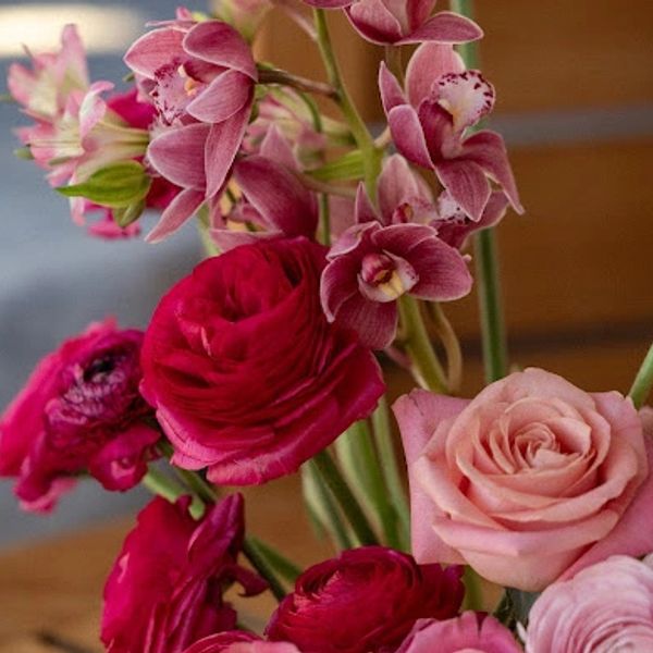 Close-up of a vibrant bouquet with pink roses and orchids.