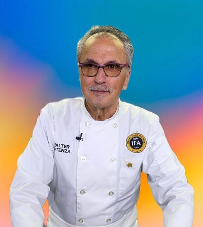 Professional chef in white coat with colorful background.