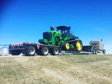 A green tractor on a truck