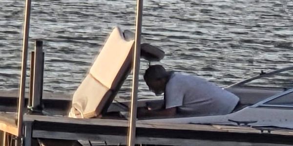Person washing clothes at the lake dock.