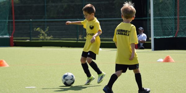 Two boys playing soccer on a field.