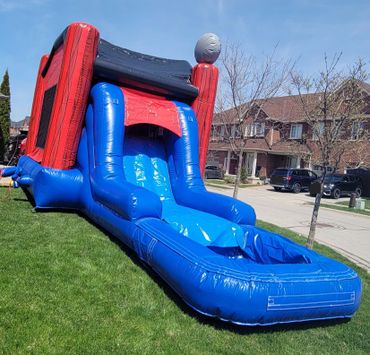 Inflatable water slide set up on a lawn in front of houses.