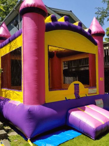 Colorful inflatable bounce house with castle design outdoors.