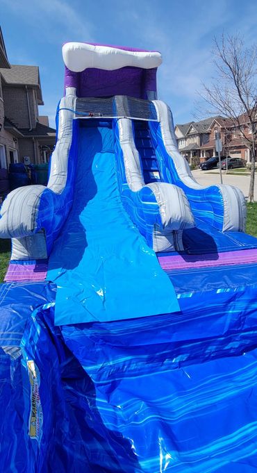 Large inflatable water slide set up in a suburban neighborhood.