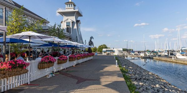 Marina with boats, flowers, and a lookout tower on a sunny day.