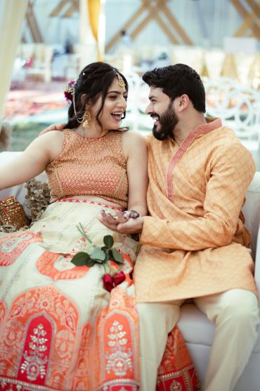 Happy couple in traditional attire sharing a joyful moment.