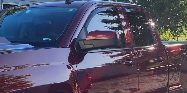 Shiny maroon pickup truck with tinted windows.