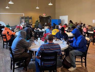 People gathered in a community hall for a meal.