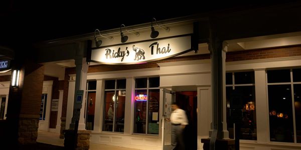 Front view of Ricky's Thai restaurant at night.
