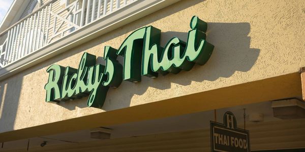 Green sign for Ricky's Thai restaurant.