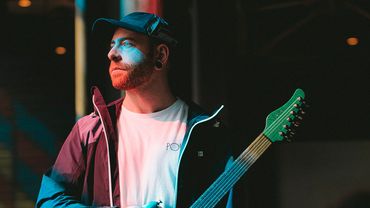 Man holding an electric guitar on stage.