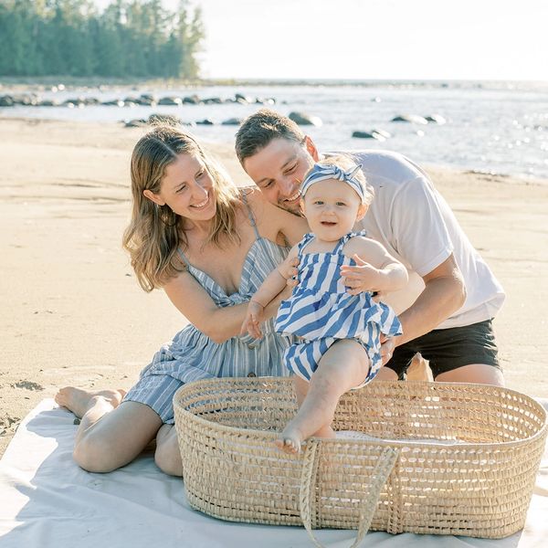 Happy family enjoying a sunny day at the beach with their baby.