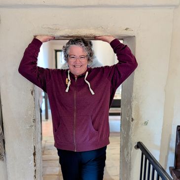 Coach Janea smiling as she holds up a doorway