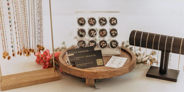 Jewelry display with necklaces, earrings, and business cards.