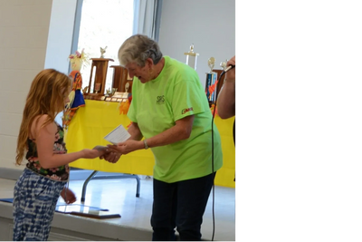 Youth exhibitor receiving her winnings cheque at the awards luncheon.