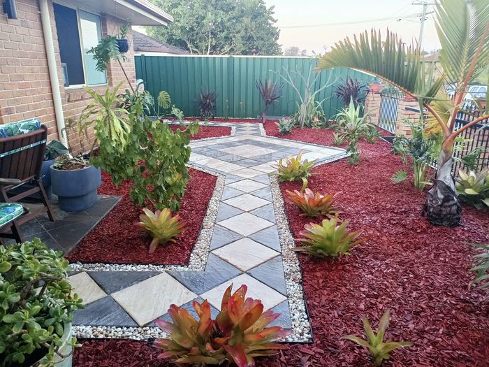 A complete remake of a yard from patchy turf to a beautiful paved garden path with red diamond mulch