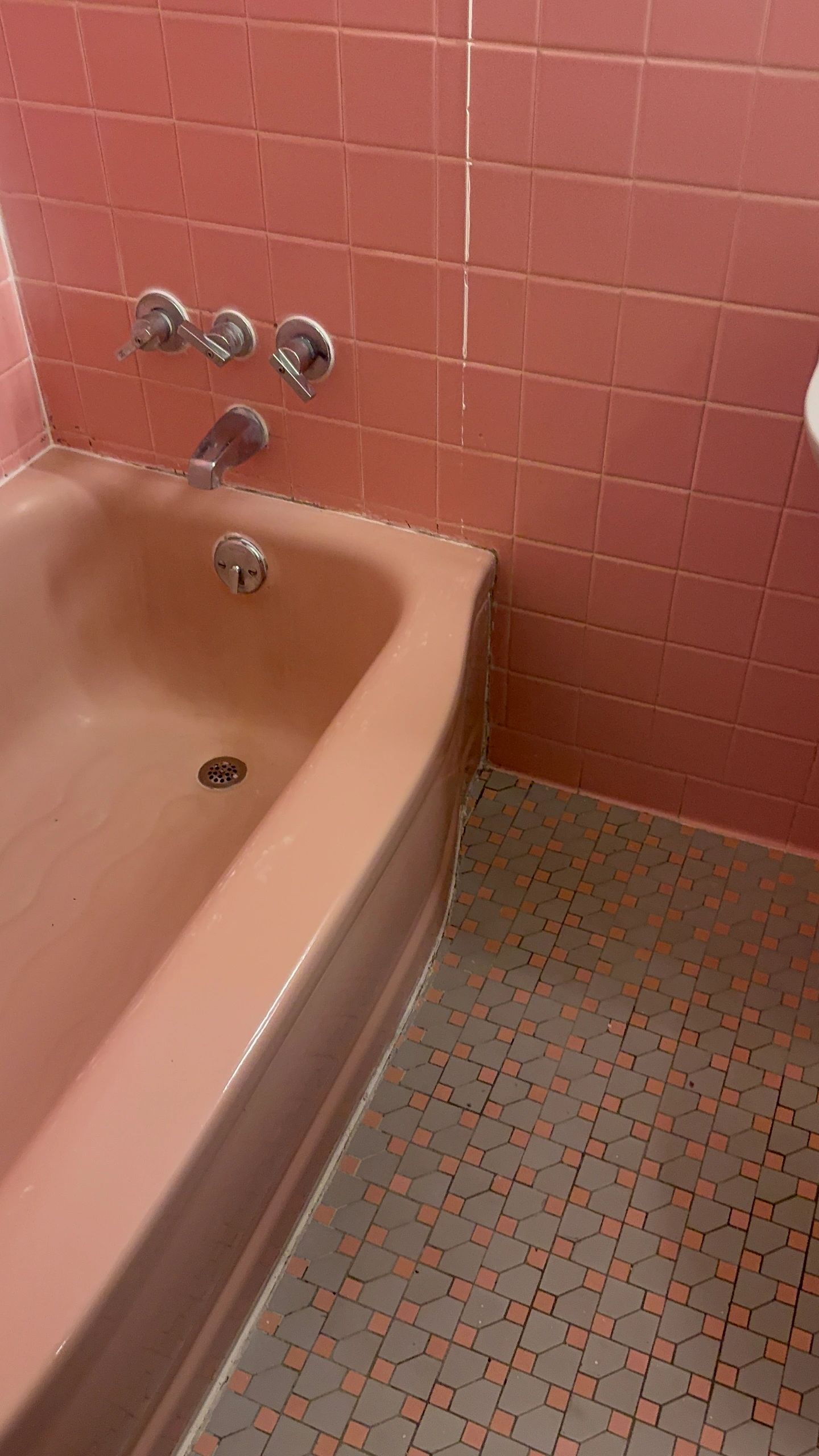 Vintage pink bathroom with tile walls and floor.