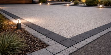 Modern driveway with sleek lighting and landscaped edges.