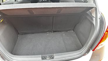 Empty car trunk with folded rear seats and black interior.