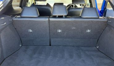 Empty car trunk with black interior and folded rear seats.