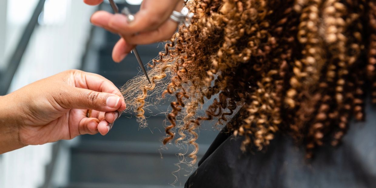 Woman cutting the curly hair of the client
