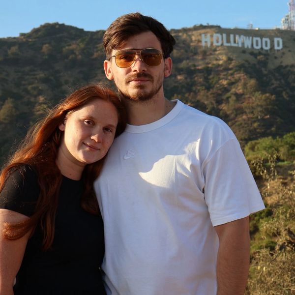 Young couple posing near Hollywood sign.