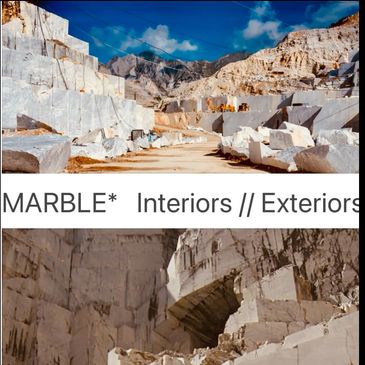 Marble quarry with large blocks of stone under a blue sky.