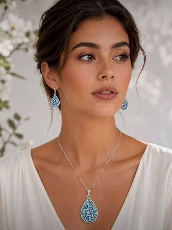 Woman wearing matching blue pendant and earrings.