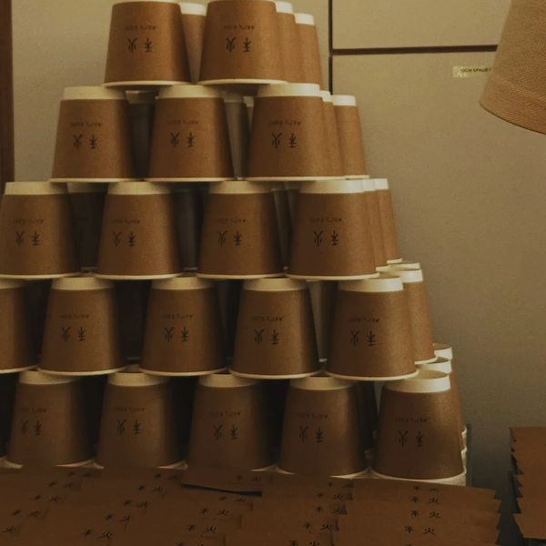 Stacked brown paper cups with black symbols on them.