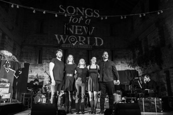 Performers stand together on stage after a show.
