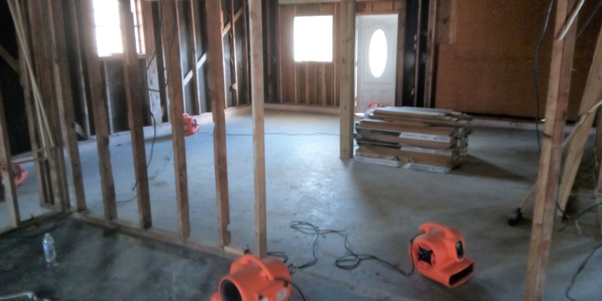 Gutted house being dried using air movers and dehumifiers.