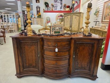 Ornate wooden sideboard with decorative items.