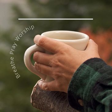 Hands holding a cup with peaceful words in the background.