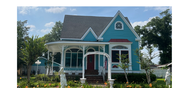 A blue house with white trim and red shutters.