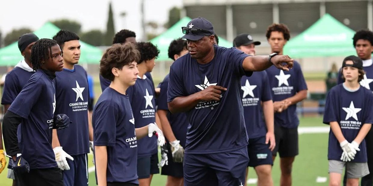 Coach instructing young athletes during a football practice session.