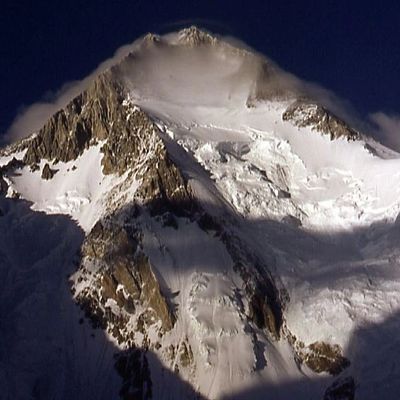 Snow-covered mountain peak under a dark sky.