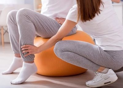 A person receiving physical therapy using an exercise ball.