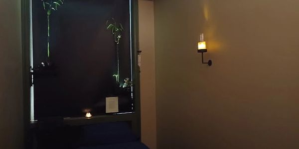 Calming peaceful candle lit bamboo plant atmosphere in a massage room at Natural Massotherapy.