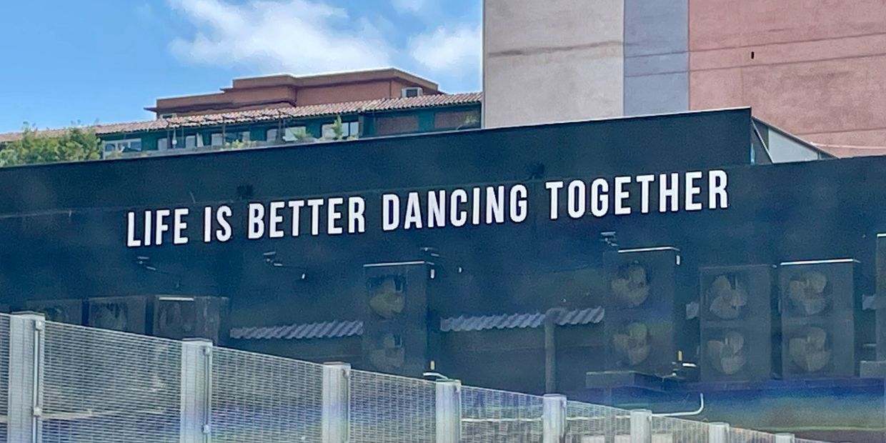 Sign reads "Life is better dancing together."