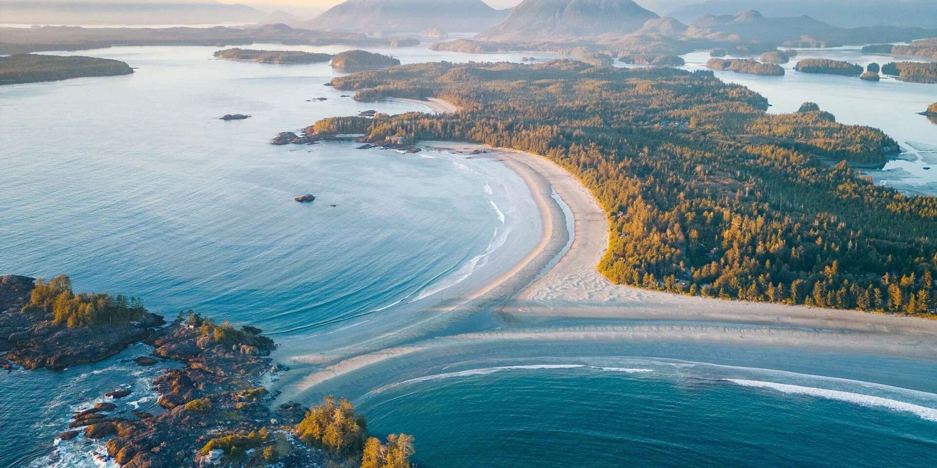 Aerial view of a scenic coastal landscape with beaches and forested islands.