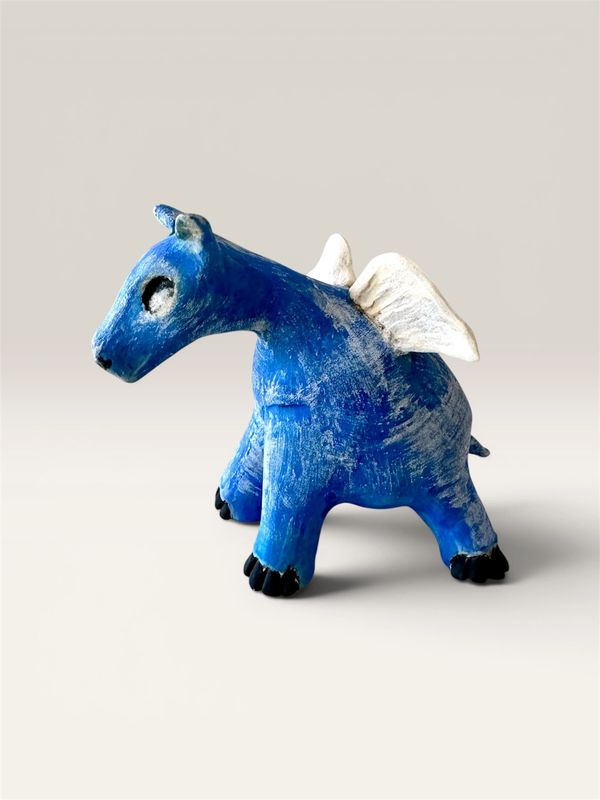 A small blue winged animal figurine with black feet and white wings.
