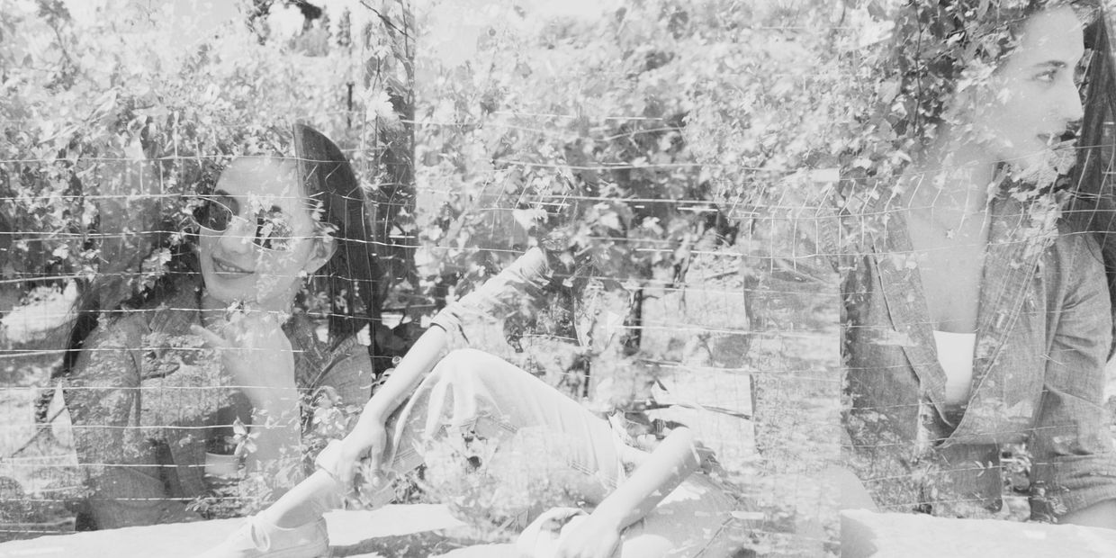 Double exposure photo of a woman in sunglasses with nature overlay.
