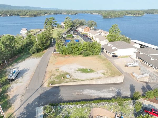 A vacant lot near a lakeside community with water and greenery.