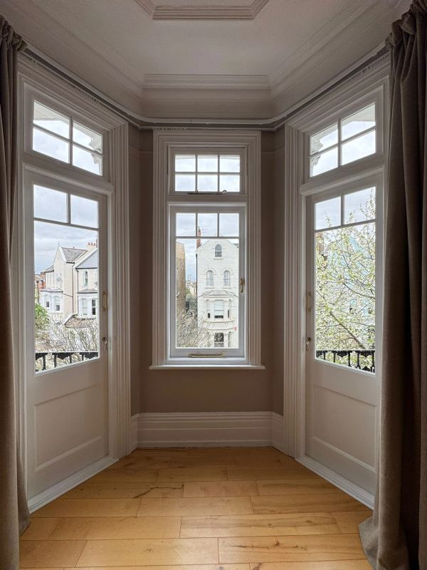 Bay window with three sections overlooking neighboring houses and trees.