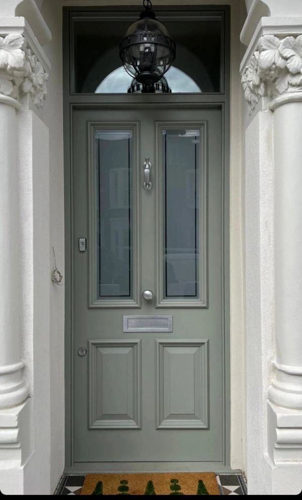 Elegant green front door with glass panels and ornate columns.