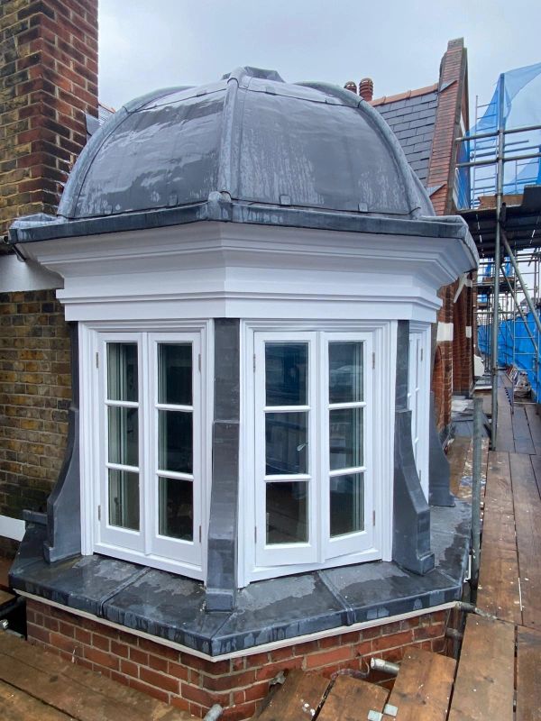 A newly constructed bay window with a domed roof on a brick building.