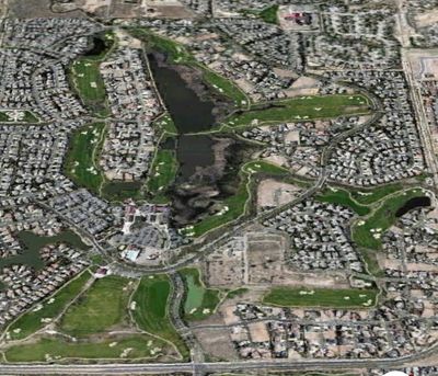 Aerial view of a residential area with a golf course and water bodies.
