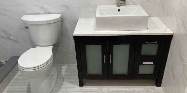 Toilet and vanity with tile wall.