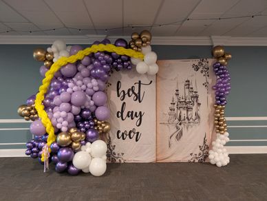Balloon arch and sign saying 'best day ever' with a castle drawing.