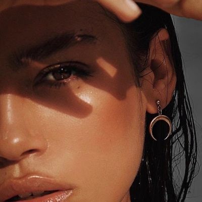 Close-up of a woman's face with crescent moon earring.